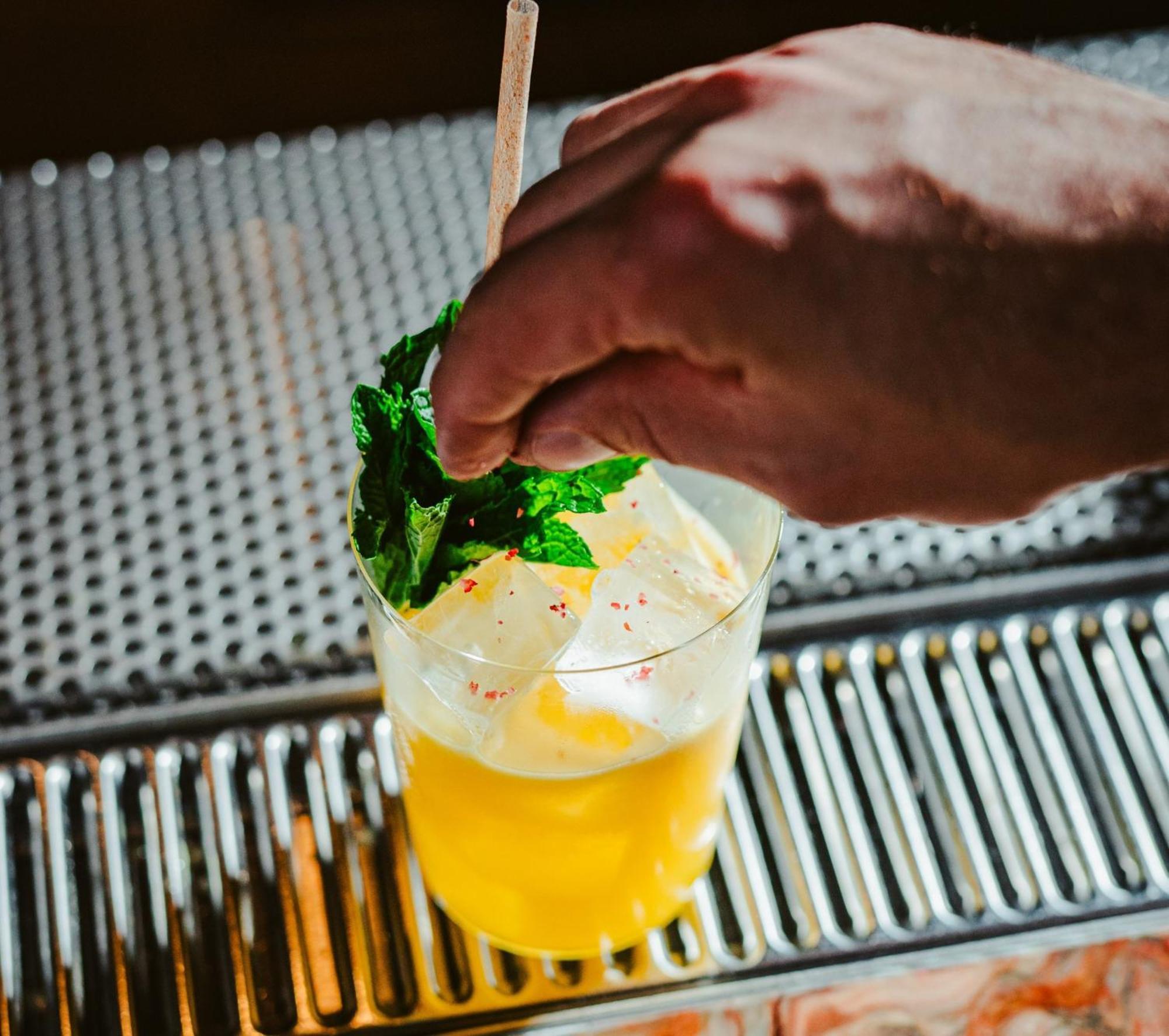 Vignette Collection Yours Truly Dc By Ihg Washington Exteriér fotografie A bartender garnishes a cocktail with mint.